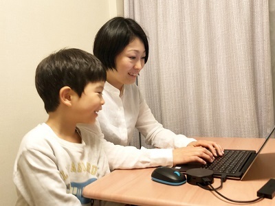 子供を横に置き在宅勤務する女性社員