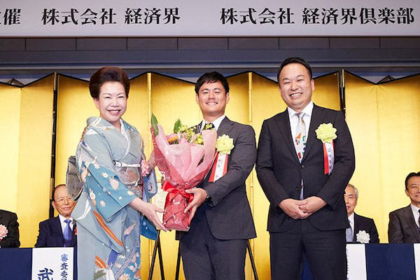 経済界GoldenPitch2023グランプリ　冨田啓輔　HelloWorld代表取締役Co-CEO、野中 光　HelloWorld代表取締役Co-CEO審査員長の各務茂夫 東京大学大学院工学系研究科技術経営戦略学専攻教授から表彰状を、弊社
