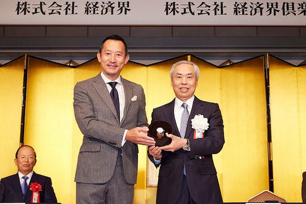 辻󠄀社長には副賞として、麦野豪　オフィス麦野代表より高級腕時計「トラベルセトロ」が贈られた