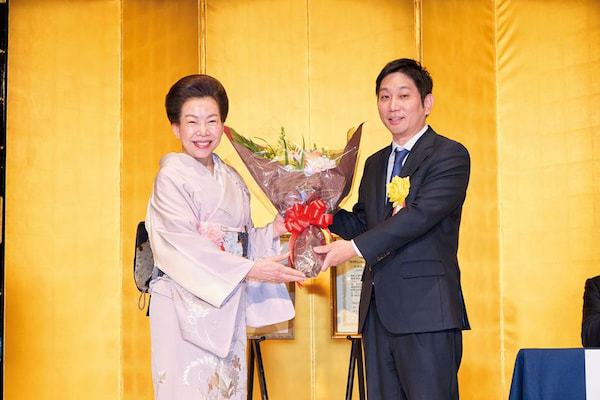 三寺歩・ミツフジ社長（右）に花束を贈呈する佐藤有美・経済界会長